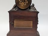 a small wooden clock with a bird on top of it