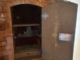 a wooden cabinet with a door open in the corner of a room