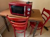 a small table with two chairs and a microwave on it