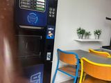 a vending machine in the corner of a kitchen
