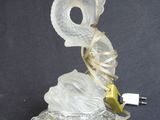 a glass lamp that has a bird on top of it