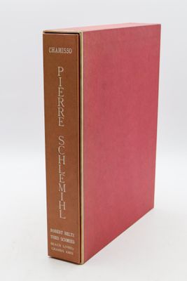 a red book with a brown cover sitting on top of a white table