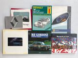 plusieurs livres posés sur une surface blanche, avec une voiture en arrière-plan