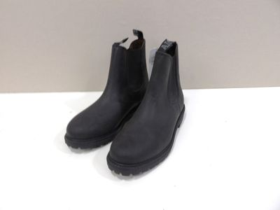 a pair of black boots on a white surface