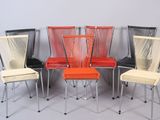 four chairs are lined up in a row on a gray surface