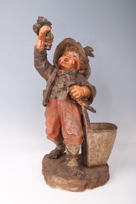 figurine of a man with a bucket and grapes in his hand