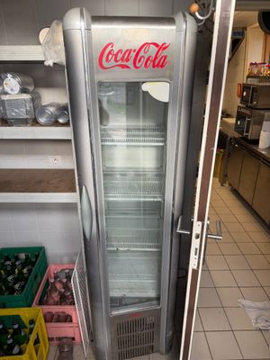 un réfrigérateur orné d'une affiche Coca-Cola dans une cuisine