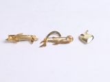 three pairs of gold plated hair clips on a white surface