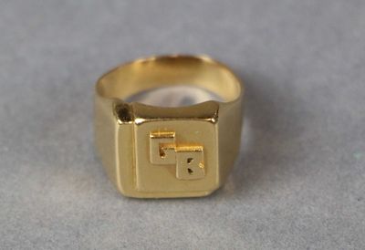 a gold ring with a cross on it sitting on a table