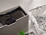 a white box with clothes inside of it next to a green cup