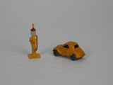 a toy car next to a gas pump on a white surface