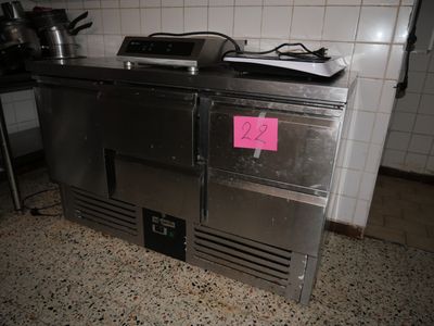 a stainless steel counter with a pink sticker on it