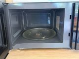 a microwave with a pan inside of it sitting on a counter