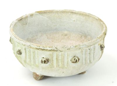 a white bowl that has holes in it on a white surface