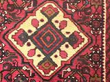 un tapis oriental orné d'un motif en losanges sur fond rouge