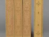 trois livres sont alignés les uns à côté des autres sur une surface grise