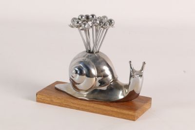 a silver sculpture of a snail with a bunch of flowers on its head