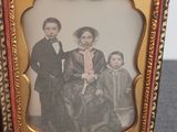 an old photo of a family posing for a picture in a gold frame