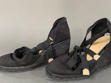 pair of women ' s black wedged shoes with bows on them