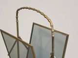 a mirror with a bamboo handle on a stand