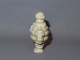 a small white figurine of a man with a hat on