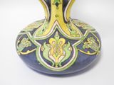 a blue vase with a yellow and green design on it