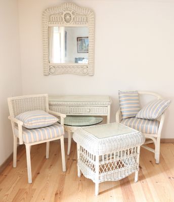 une table et des chaises dans une pièce où un miroir est accroché au mur