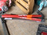 un tuyau rouge posé par terre à côté d'une caisse en bois