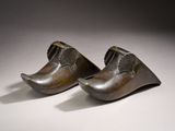 a pair of bronze shoes are sitting on a white surface