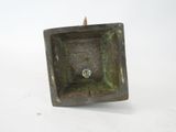 a small square metal object on a white surface