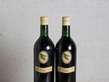 deux bouteilles de vin posées sur une table l'une à côté de l'autre