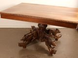 a wooden table with carvings on it in the corner of a room