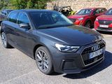 the audi audis are parked in a parking lot with other cars in the background