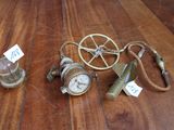 trois horloges posées sur une table en bois, accompagnées d'étiquettes