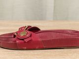 a close up of a red shoe on a wooden table