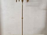 an antique brass floor lamp with black shades on a wooden floor