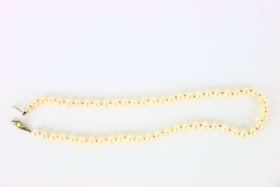 a white beaded necklace on a white background