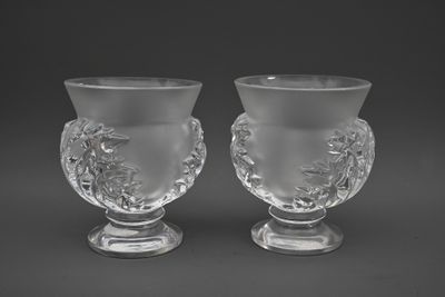 une paire de vases en verre transparent posés sur des socles, sur fond noir