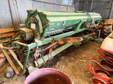une grosse machine verte qui est garée dans la poussière