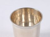 a silver cup that is sitting on a white surface