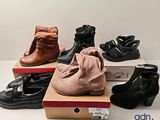 plusieurs paires de chaussures pour femmes posées sur des cartons, sur une table