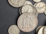 some silver coins are scattered on a black surface