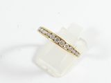 a yellow gold ring with diamonds on a white background