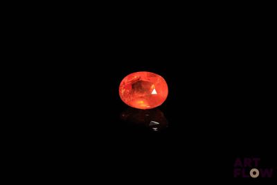 a close up of a red stone on a black surface