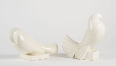 pair of white ceramic birds on stands on a white background