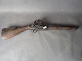 a close up of a rifle with a wooden handle on a table