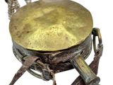 a brass plate on a wooden stand with a leather strap around it