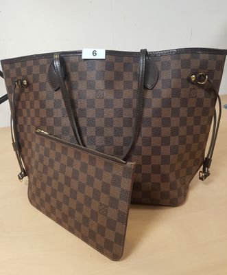un sac marron et noir posé sur une table en bois