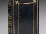 un livre noir avec des finitions dorées et une bordure dorée