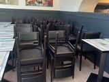 many chairs and tables in a room with a painting on the wall